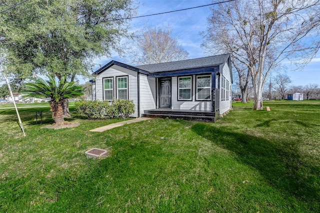 1316 Bailey St, Wharton, TX 77488 - view of front of home featuring a front lawn, a shingled roof, and a porch
