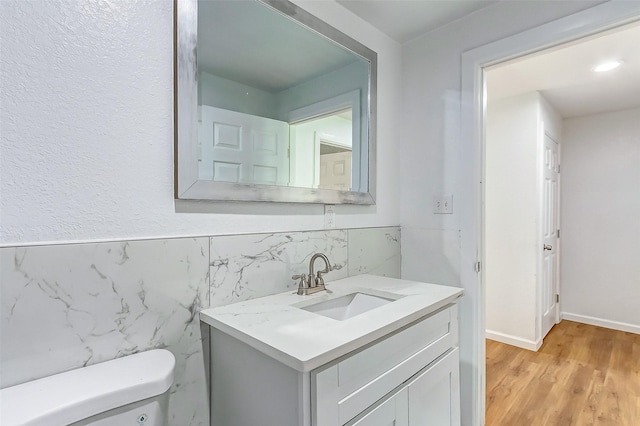 1316 Bailey St, Wharton, TX 77488 - half bathroom with vanity, toilet, wood finished floors, and tile walls