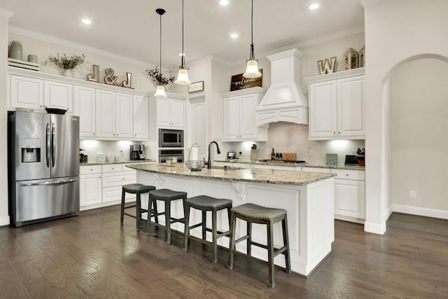 510 Blossom Cove Ct, Pinehurst, TX 77362 - kitchen with appliances with stainless steel finishes, recessed lighting, white cabinets, a sink, and a kitchen island with sink