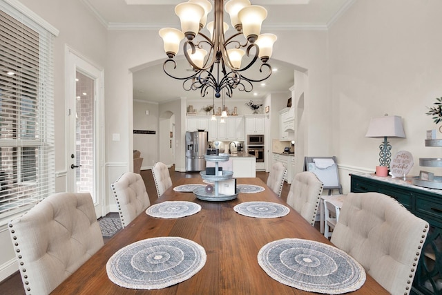 510 Blossom Cove Ct, Pinehurst, TX 77362 - dining area featuring a chandelier, ornamental molding, arched walkways, and wood finished floors