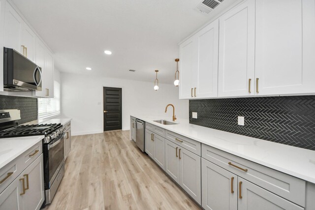 5638 N Braeswood Blvd, Houston, TX 77096 - kitchen with appliances with stainless steel finishes, tasteful backsplash, a sink, light wood-type flooring, and light countertops