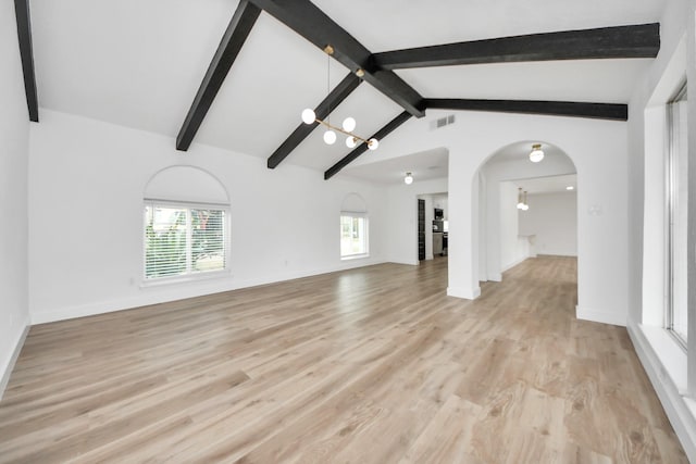 5638 N Braeswood Blvd, Houston, TX 77096 - unfurnished living room with arched walkways, light wood-type flooring, and baseboards