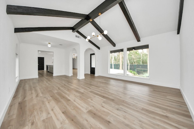 5638 N Braeswood Blvd, Houston, TX 77096 - unfurnished living room featuring arched walkways, a chandelier, light wood finished floors, and baseboards