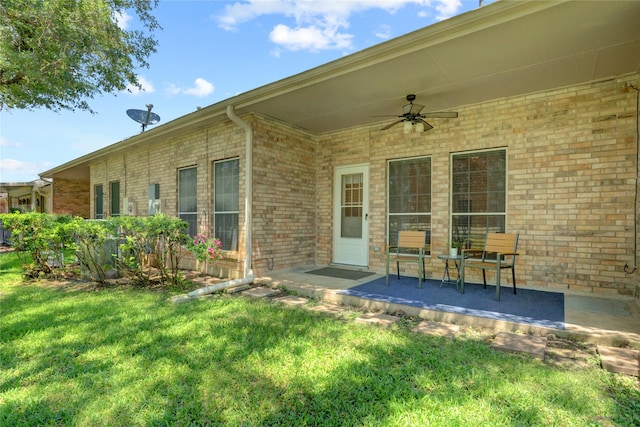 734 E Country Grove Cir, Pearland, TX 77584 - view of exterior entry featuring a ceiling fan, a yard, and brick siding