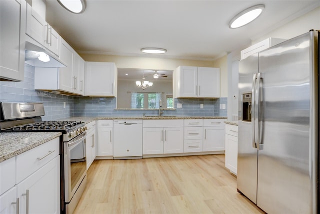 734 E Country Grove Cir, Pearland, TX 77584 - kitchen featuring appliances with stainless steel finishes, a sink, under cabinet range hood, white cabinets, and crown molding