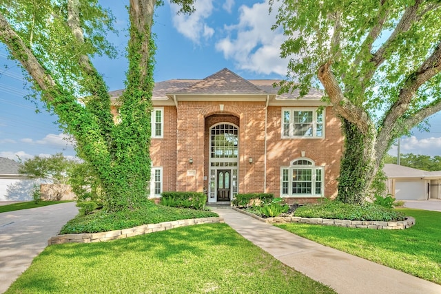 4106 Alice Dr, Sugar Land, TX 77478 - traditional-style home featuring brick siding, a front yard, and a shingled roof