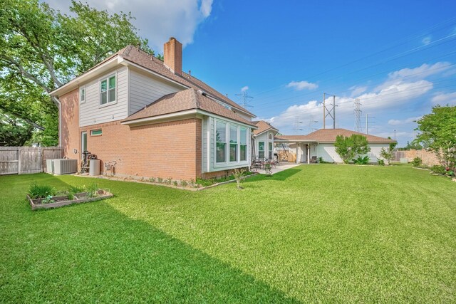 4106 Alice Dr, Sugar Land, TX 77478 - back of house with brick siding, a chimney, central AC unit, a shingled roof, and a patio area