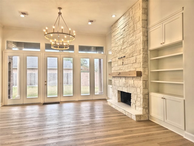9923 Eden Valley Dr, Spring, TX 77379 - unfurnished living room with a chandelier, ornamental molding, a fireplace, light wood-style floors, and built in shelves