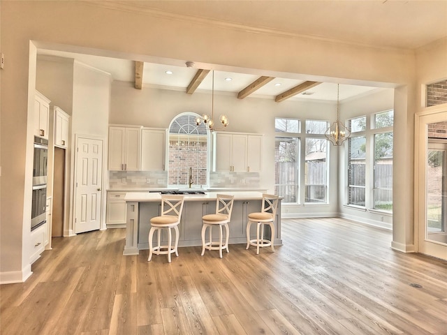 9923 Eden Valley Dr, Spring, TX 77379 - kitchen featuring a chandelier, beam ceiling, white cabinets, light countertops, and a center island