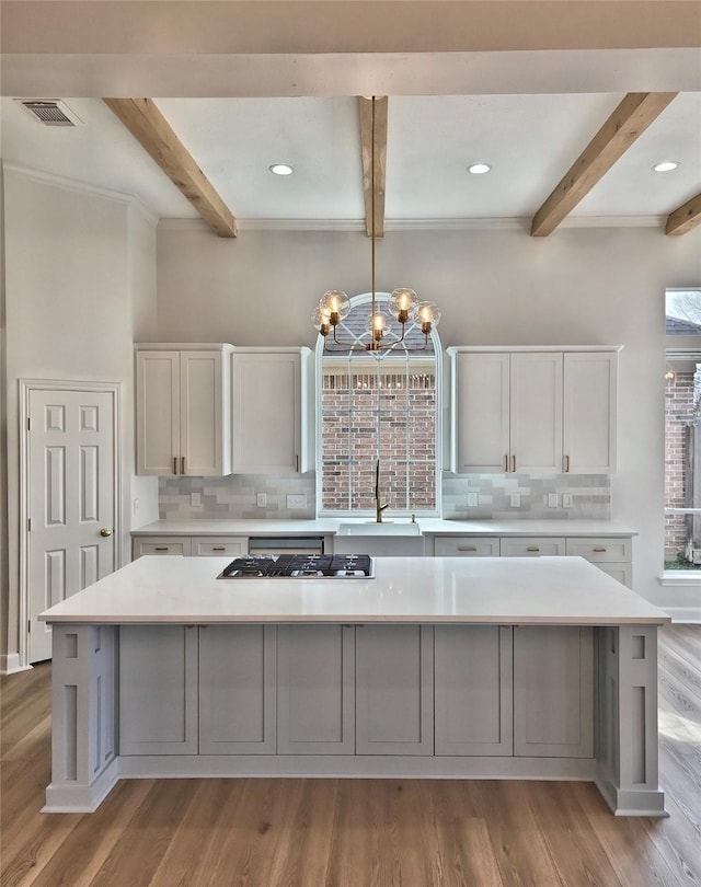 9923 Eden Valley Dr, Spring, TX 77379 - kitchen with a sink, beam ceiling, decorative backsplash, light countertops, and light wood-style floors