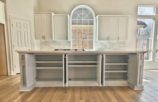 9923 Eden Valley Dr, Spring, TX 77379 - kitchen featuring open shelves, light wood-style floors, and backsplash