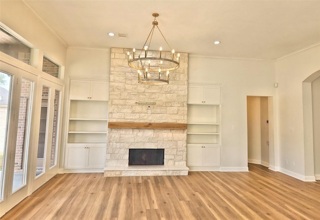 9923 Eden Valley Dr, Spring, TX 77379 - unfurnished living room featuring ornamental molding, light wood-style floors, a chandelier, arched walkways, and baseboards