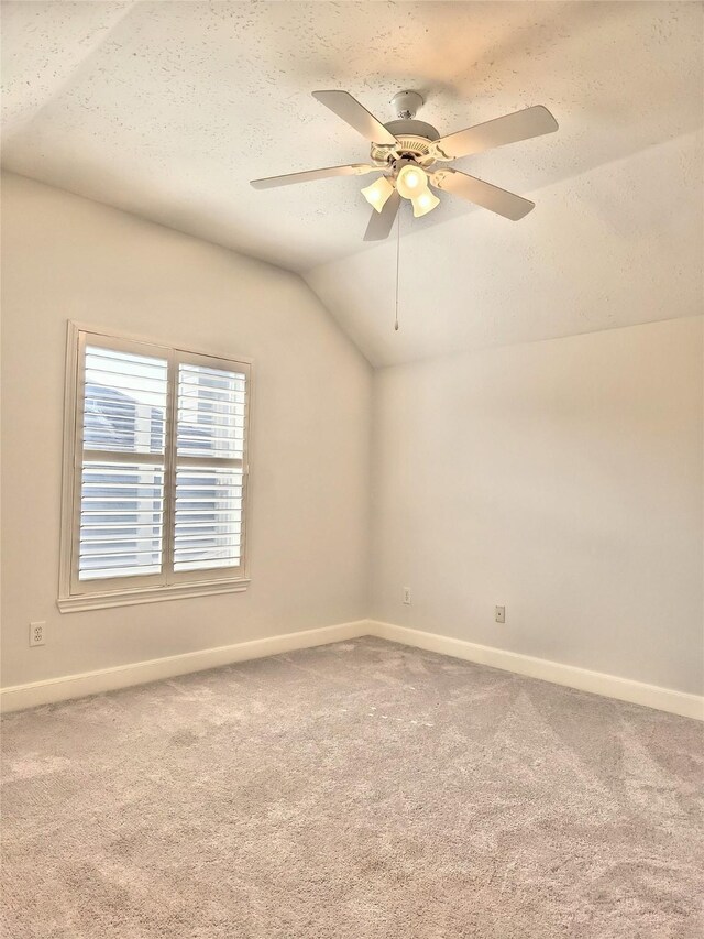 9923 Eden Valley Dr, Spring, TX 77379 - spare room featuring lofted ceiling, carpet, baseboards, and a textured ceiling