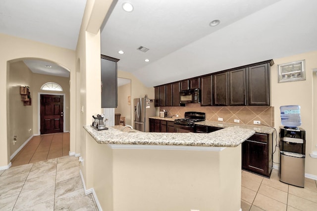 3018 Wellington Pass Dr, Spring, TX 77373 - kitchen featuring black appliances, arched walkways, light tile patterned flooring, dark brown cabinetry, and vaulted ceiling