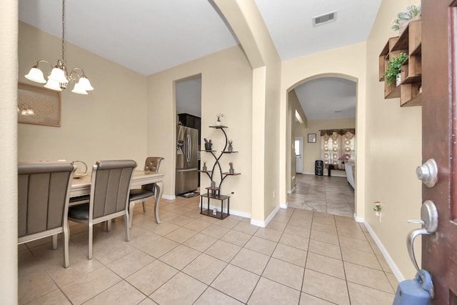3018 Wellington Pass Dr, Spring, TX 77373 - dining area with arched walkways, light tile patterned flooring, a chandelier, and baseboards