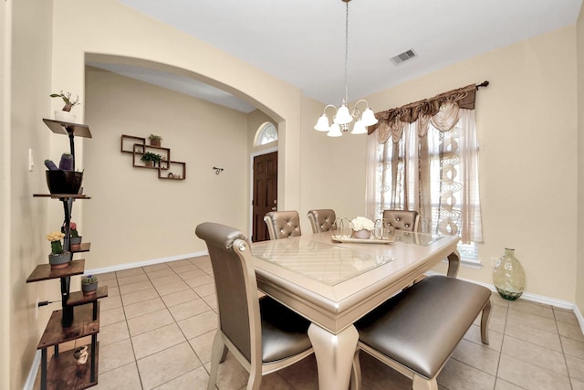3018 Wellington Pass Dr, Spring, TX 77373 - dining area featuring arched walkways, a chandelier, light tile patterned flooring, and baseboards