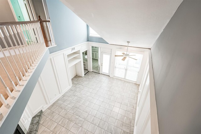 4315 Westheimer Rd, Houston, TX 77027 - unfurnished living room featuring a decorative wall, wainscoting, and a ceiling fan