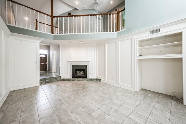 4315 Westheimer Rd, Houston, TX 77027 - unfurnished living room with a decorative wall, high vaulted ceiling, ceiling fan, and a fireplace with raised hearth