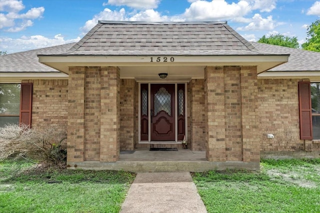 1520 Sycamore St, Navasota, TX 77868 - view of exterior entry with a shingled roof and brick siding