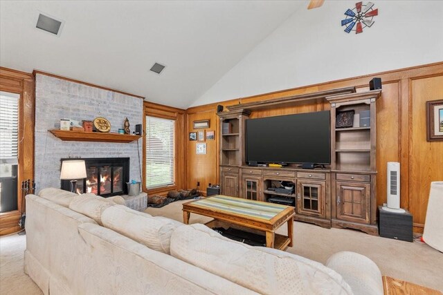 1520 Sycamore St, Navasota, TX 77868 - carpeted living area with high vaulted ceiling, a brick fireplace, and wooden walls