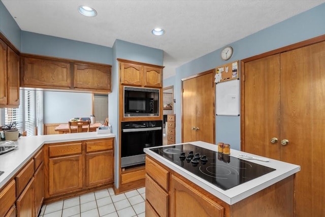 1520 Sycamore St, Navasota, TX 77868 - kitchen with black appliances, brown cabinets, light countertops, light tile patterned flooring, and recessed lighting