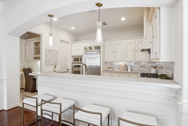 614 W Bell St Unit A, Houston, TX 77019 - kitchen featuring built in appliances, decorative backsplash, light countertops, white cabinetry, and crown molding