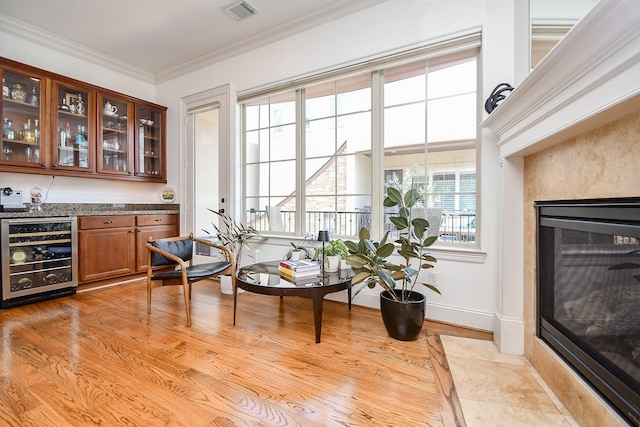4006 Feagan St Unit D, Houston, TX 77007 - bar with wine cooler, a fireplace with flush hearth, crown molding, light wood-type flooring, and baseboards
