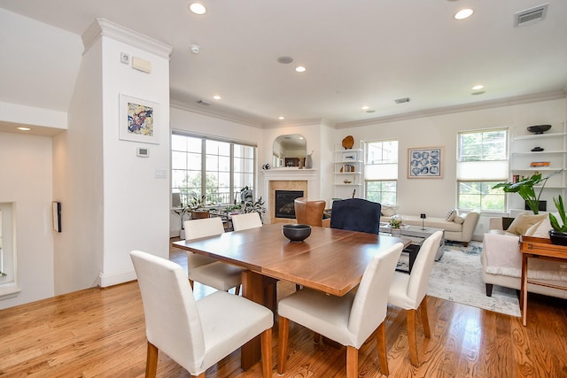 4006 Feagan St Unit D, Houston, TX 77007 - dining area featuring a glass covered fireplace, light wood finished floors, recessed lighting, crown molding, and built in features