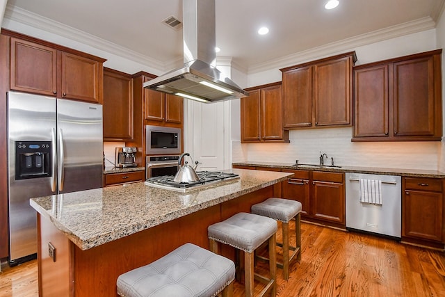 4006 Feagan St Unit D, Houston, TX 77007 - kitchen featuring stainless steel appliances, island range hood, a sink, light stone countertops, and a kitchen breakfast bar