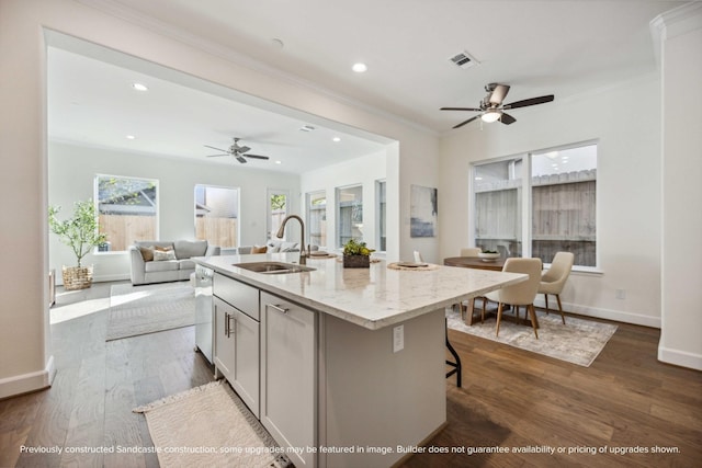 222 E 27th St, Houston, TX 77008 - kitchen with a sink, open floor plan, a kitchen island with sink, crown molding, and light stone countertops