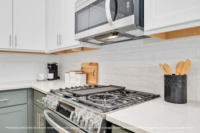 222 E 27th St, Houston, TX 77008 - kitchen with appliances with stainless steel finishes, light countertops, backsplash, and white cabinets