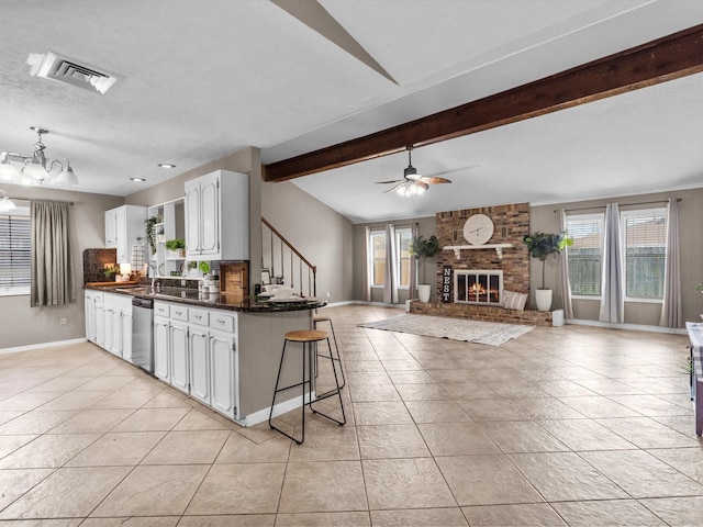 3309 Westbrook Cir, Pasadena, TX 77503 - kitchen featuring dark countertops, stainless steel dishwasher, baseboards, a brick fireplace, and light tile patterned flooring