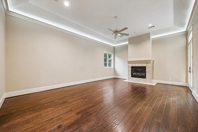 3110 Noble Lakes Ln, Houston, TX 77082 - unfurnished living room featuring a tray ceiling, dark wood-style floors, ceiling fan, a tiled fireplace, and baseboards