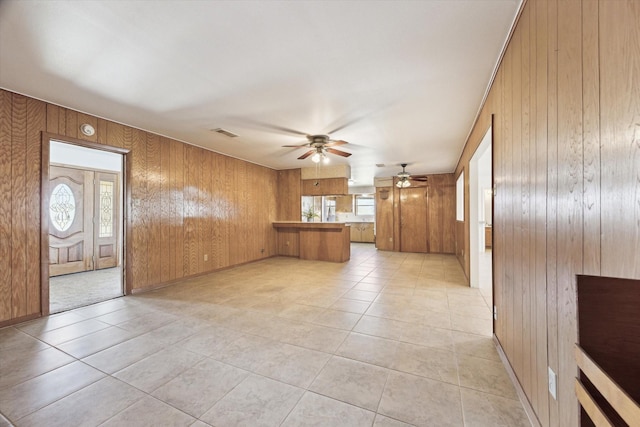 17019 Mclean Rd, Pearland, TX 77584 - unfurnished living room featuring wooden walls, a ceiling fan, plenty of natural light, and light tile patterned floors