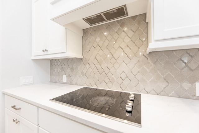 29446 Pearwood Dr, Katy, TX 77494 - kitchen featuring black electric stovetop, extractor fan, white cabinetry, and decorative backsplash