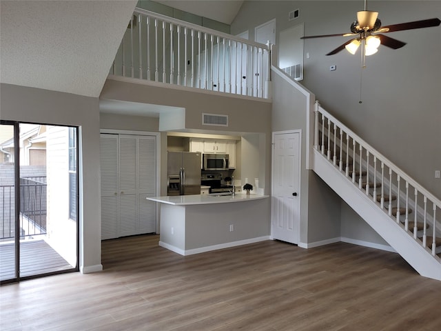 2300 Old Spanish Trl Unit 2136, Houston, TX 77054 - unfurnished living room with high vaulted ceiling, stairs, wood finished floors, and ceiling fan