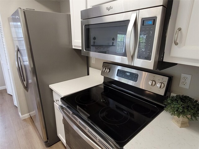 2300 Old Spanish Trl Unit 2136, Houston, TX 77054 - kitchen featuring stainless steel appliances, white cabinetry, light wood-style floors, and baseboards
