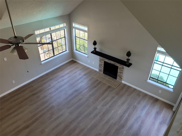 2300 Old Spanish Trl Unit 2136, Houston, TX 77054 - unfurnished living room with vaulted ceiling, baseboards, wood finished floors, ceiling fan, and a stone fireplace