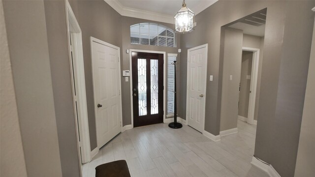 1314 Caravelle Ct, Katy, TX 77494 - entrance foyer featuring a chandelier, crown molding, baseboards, and light wood-style flooring