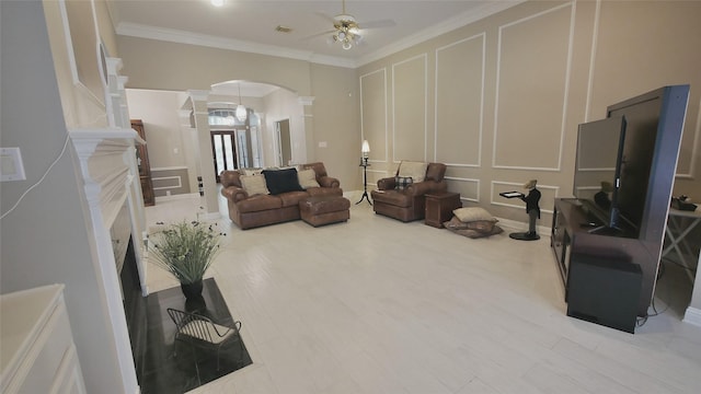 1314 Caravelle Ct, Katy, TX 77494 - living area featuring ornate columns, arched walkways, a decorative wall, ceiling fan, and crown molding