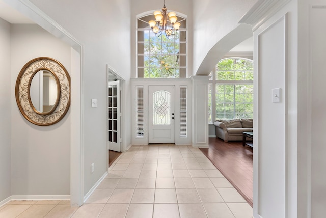 37 S Piney Plains Cir, The Woodlands, TX 77382 - foyer featuring a chandelier, a towering ceiling, light tile patterned flooring, and baseboards