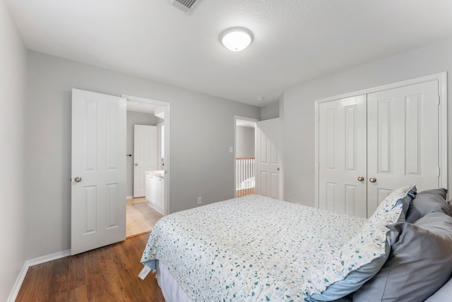 37 S Piney Plains Cir, The Woodlands, TX 77382 - bedroom featuring a closet, baseboards, wood finished floors, and connected bathroom