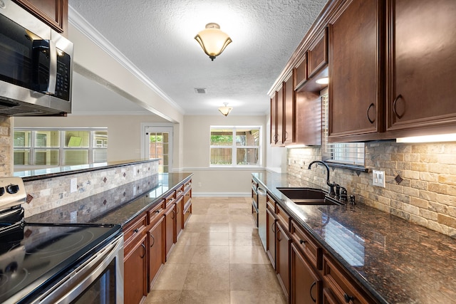 11243 Rousseau Dr, Houston, TX 77065 - kitchen featuring appliances with stainless steel finishes, a sink, tasteful backsplash, a textured ceiling, and baseboards
