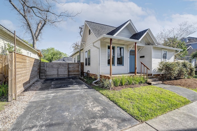 1016 Louise St, Houston, TX 77009 - view of front of home featuring driveway, a shingled roof, fence, and covered porch