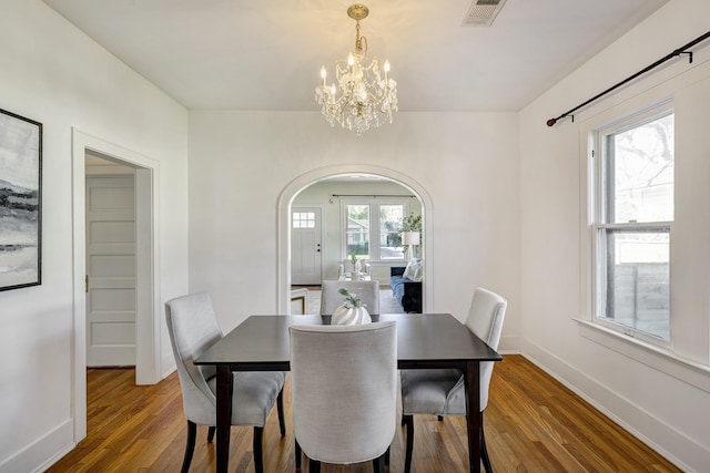 1016 Louise St, Houston, TX 77009 - dining area with arched walkways, wood finished floors, a chandelier, and baseboards