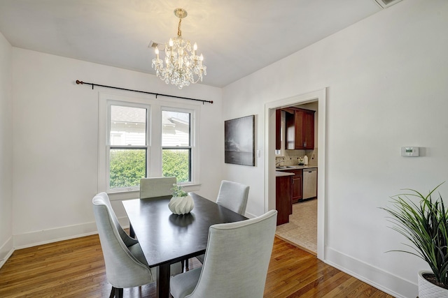 1016 Louise St, Houston, TX 77009 - dining space featuring a chandelier, baseboards, and light wood-style flooring