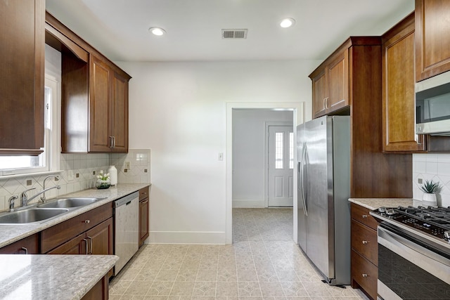 1016 Louise St, Houston, TX 77009 - kitchen featuring stainless steel appliances, a sink, baseboards, light countertops, and backsplash