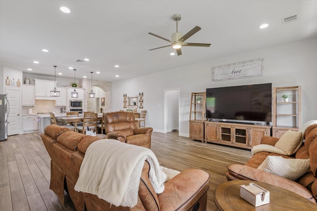 living area featuring ceiling fan, light wood-type flooring, recessed lighting, and baseboards
