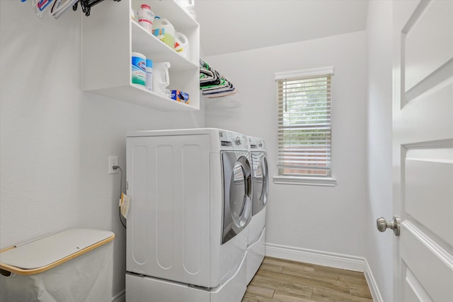 laundry area with separate washer and dryer, light wood-style floors, and baseboards