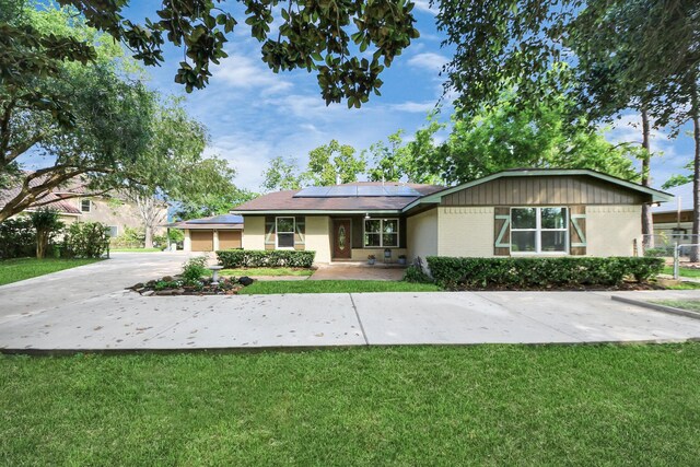 5103 Diamond Springs Dr, Missouri City, TX 77459 - ranch-style house featuring solar panels, a front yard, brick siding, and concrete driveway